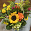Golden Meadow is a cheerful, lush arrangement featuring bright sunflowers, and warm