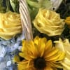 Nestled in a lovely white basket are lovely orchid, yellow roses, baby