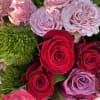 Array of roses in burgundy, wine and pink tones, accented with tropical