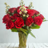 A classic bouquet of 2 dosen vibrant red roses paired with delicate