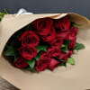 One dozen long stem red roses hand wrapped in brown paper. This