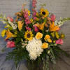 Sunset colors and sweet summer flowers are hand arranged in this large
