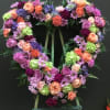 This open heart made with green hydrangea, purple roses, carnations , daosy.