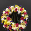 This beautiful wreath made with hot pink roses, yellow liliez white carnations