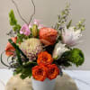 A vibrant and dynamic arrangement featuring a lively mix of peach, pink