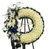 This standing wreath is full in white flowers with blue and green