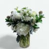 This beautiful white arrangement has hydrangeas, brassica, roses, spray roses, rice flower
