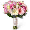 Mixed floral bouquet in soft pink and yellow hues wrapped in white
