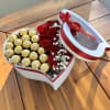 Beautiful heart-shaped box filled with red roses and Ferrero Rocher.