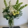 A display of white flowers in a tall vase to create a