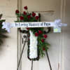 White Carnation filled Cross with red roses spread diagonally spread. 