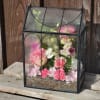 A beautiful and classic terrarium shaped like a house, with lovely arched