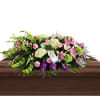 A beautiful and elegant casket spray featuring a mix of pink roses