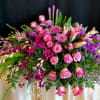 A tropical and romantic mix of fresh orchids, roses, and lilies in
