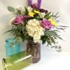 Colorful jars with a hammered design. A nice mix of flowers. Fun