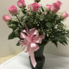 A beautiful arrangement of one dozen pink roses, accented with baby&#039;s breath