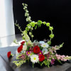 This elegant arrangement includes our most beautiful flowers and a resting Angel