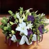 A floral arrangement in a white ceramic shell vase that brings freshness