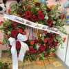 This beautiful red and green funeral wreath signifies the peaceful celebration of