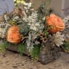 Peach colored flowers such as Roses, Wax Flowers, Pine and Dusty Miller.