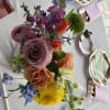 Beautiful asymmetrical center piece with variety of colors and flowers that are