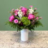 A striking mixed arrangement showcasing a vibrant hot pink, green, and white