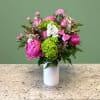 A striking mixed arrangement showcasing a vibrant hot pink, green, and white