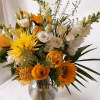 A beautiful vase of yellow and white flowers artfully arranged. Standard is