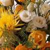 A beautiful vase of yellow and white flowers artfully arranged. Standard is