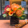 Tropical and sophisticated selection of protea, calla lilies and berries designed in