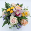 Poppy features a Pink Cymbidium Orchid bloom, Blush Pink Roses, Peach Roses