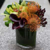The arrangement is presented in a fish eye vase. It includes all