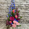 This elegant sympathy arrangement blends soothing shades of blue, gentle lavender, and