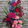 This elegant sympathy arrangement blends soothing shades of blue, gentle lavender, and