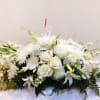 Formal casket style with the mix of white and green seasonal flowers.
