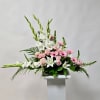 This Arrangement includes White Gladiola, White Lily, White Snapdragon, Light Pink Roses