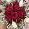 red roses and tulips arranged in a hand bouquet 