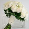 A classic bouquet of cream roses, white hydrangeas, white lisianthus, and stephanotis