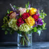 This cheerful arrangement bursts with vibrant yellow and red roses, nestled among