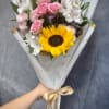  A sweet hand-tied bouquet featuring a bright sunflower, delicate pink spray