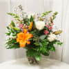 Classic roses and lilies in a loose, airy arrangement with a strong