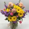 A bright combination of yellow daisies, purple stock, peach roses and pink
