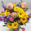 A bright combination of yellow daisies, purple stock, peach roses and pink