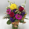 A mix of fresh, seasonal flowers designed in a handled mason jar