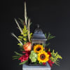 An artistic black lantern adorned with beautiful fall flowers that will bring
