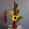 This arrangement in a deep amber glass vase not only embodies the