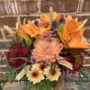 Lilies, chrysanthemums, thistle, accent flowers, dried wheat, and assorted greenery. Arranged in