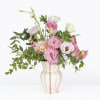 Full arrangement filled with local lisianthus and eucalyptus in a ceramic striped