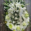 A serene expression of sympathy, this elegant wreath features white lilies, roses