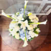 This centerpiece is an elegant, symmetrical floral arrangement featuring a refined palette
